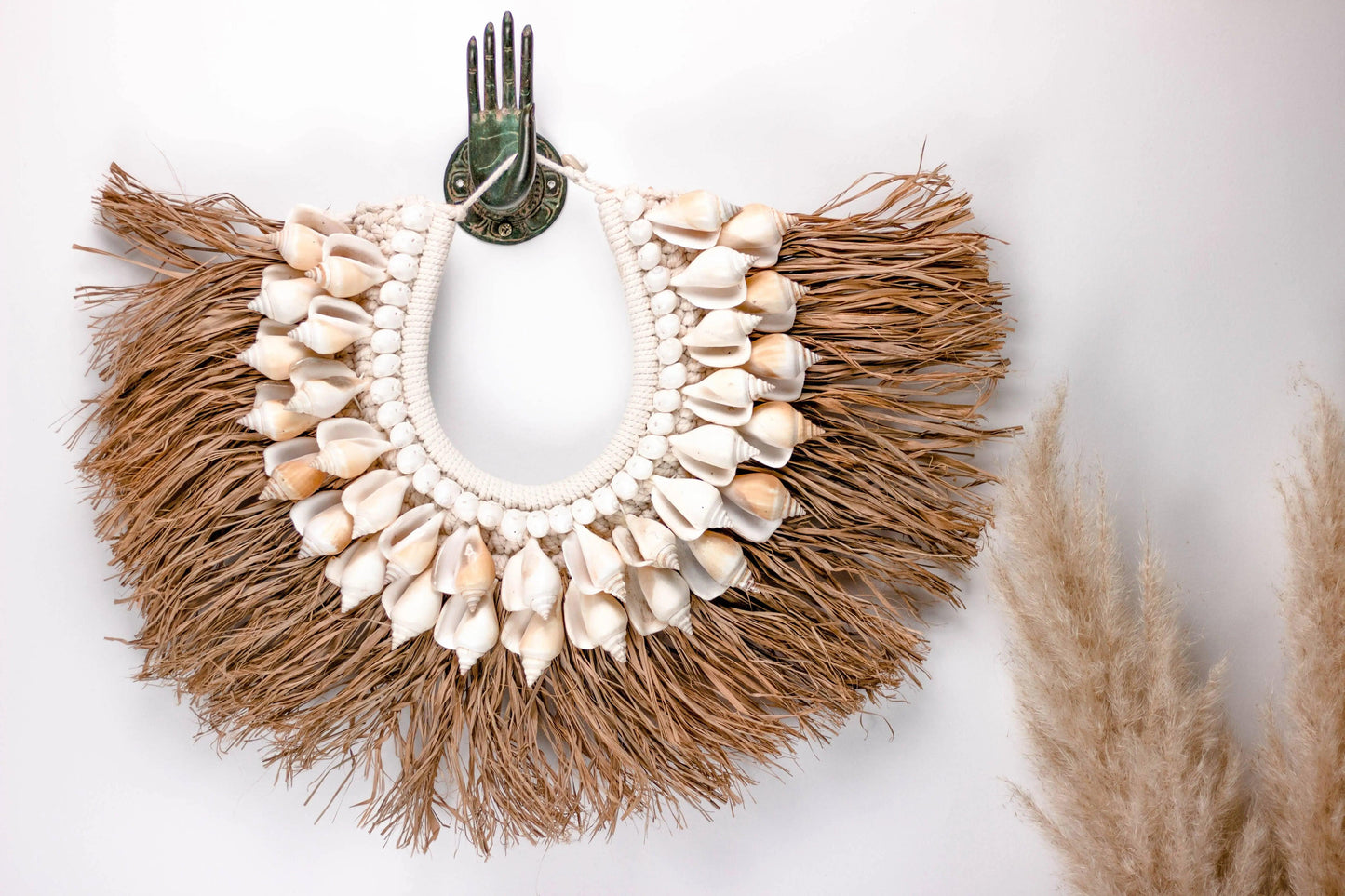 Tropischer Wandschmuck mit Muschelverzierung und Raffia für entspanntes Urlaubsfeeling